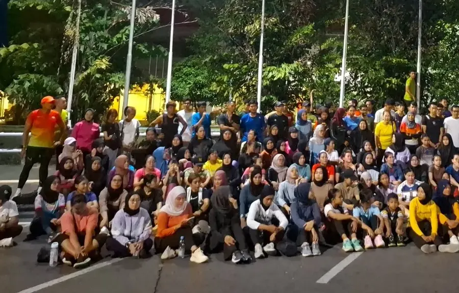 Peserta duduk beristirahat dan minum setelah latihan Sparko
